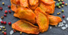 Carrot chips on slate surrounded by salt and peppercorns