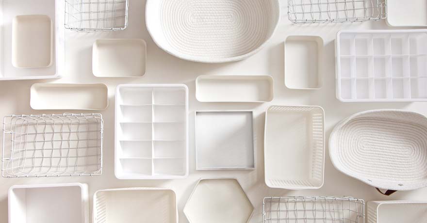 white plates, bowls and storage container on white table, top view