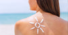 Woman with sunscreen on back in shape of the sun