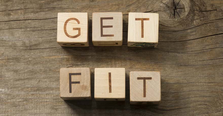 Wooden letter cubes on table displaying the message, " Get Fit"