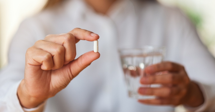 woman holding supplement up close