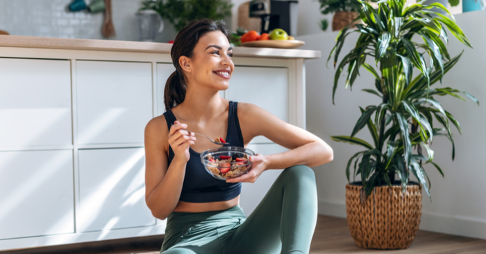 woman sitting on floor with bowl of fruit